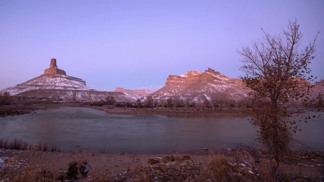 Time lapse of desert landscape at dawn as the sky changes color viewing the alpenglow over the Green River in Utah.