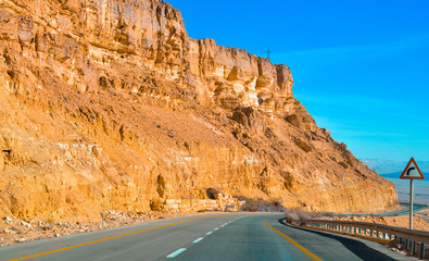 empty road with right turn in a mountains in desert in middle east colorful