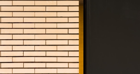 A white tiled wall with orange stripes and gray area