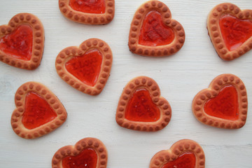 Biscuit in form of red hearts for gift card. Romantic bakery. Biscuit sweet cookie background.