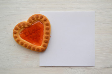 Candy heart. Card with red cookie in form of heart wit paper for copyspace