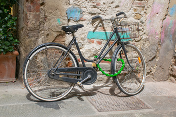 Bicycle parked by an ancient wall in Bologna.