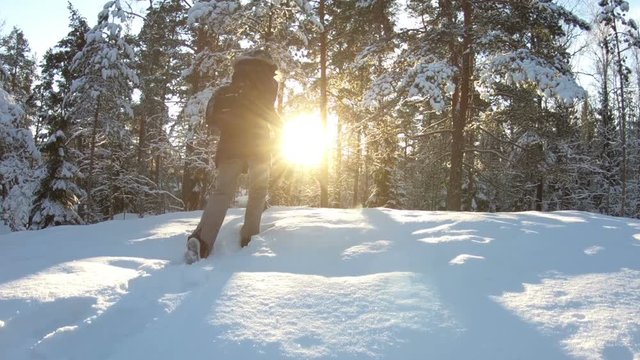 Young woman with professional photo camera in the winter forest. Forest in snow near the Espoo. Finland.