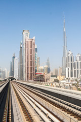 Fototapeta na wymiar Tracks of an elevated stretch of Dubai metro and Burj Khalifa skyscraper, United Arab Emirates