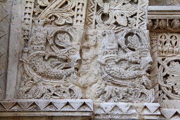 mascheroni a capo dell'arco; primo portale sul fianco nord della Cattedrale dell'Assunta a Conversano (Puglie)