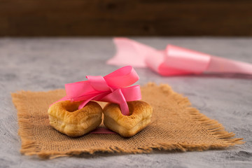 Two heart shaped cookies. Pink ribbon with bow. The symbol of mutual love. A gift on Valentine's Day.