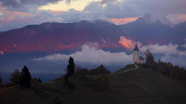 Sunset over Jamnik, Slovenia. Aerial drone view over Alps and Church St. Primoz.