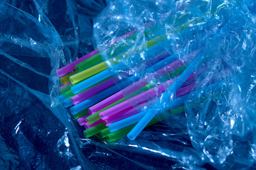 plastic waste. crumpled plastic film and cocktail tubes