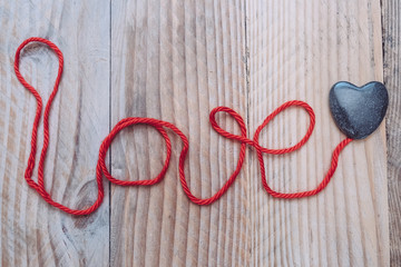 Fond love et coeur en fil rouge sur un fond bois vieilli