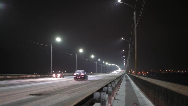 Cars Drive Over The Snow Bridge At Night