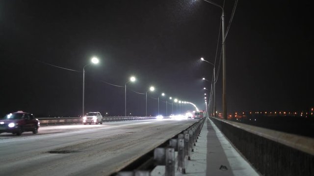 Accelerated Motion, Night Motion of Cars through the Bridge in a Snowstorm