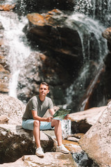 Fototapeta na wymiar Man enjoying view of waterfall in gungle