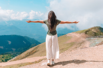 Beautiful happy young woman in mountains in the background of fog © travnikovstudio
