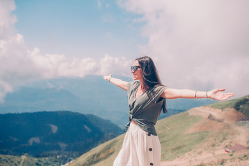 Beautiful happy young woman in mountains in the background of fog