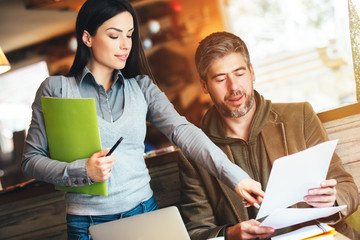 Man and woman in cafe discussing contract