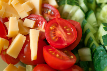 Tomatoes, cucumbers and pieces of cheese assorted in salad. Healthy food, diet concept