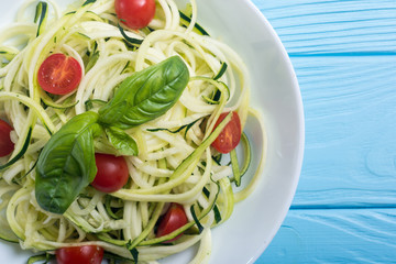 Zucchini pasta noodles with tomatoes . Healthy vegetarian food