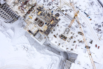 aerial top view of construction site in winter. building of new apartments under white snow
