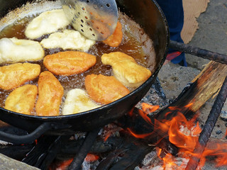 Traditional ecuadorian sweet food - Cheese Empanadas cooked on open fire in big pot with oil