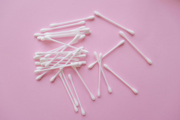 white plastic cotton buds on a pink background, Flat lay, view from above
