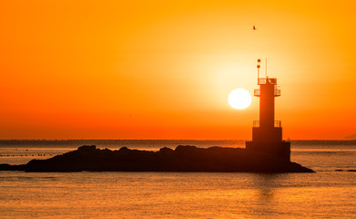 등대 너머에서 떠오르는 태양