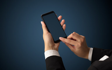 Mockup for female hand using frameless smartphone with dark background
