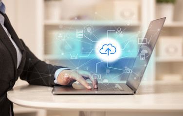 Business woman in homey environment using laptop with  online storage and cloud technology concept
