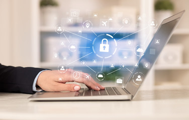 Business woman below chest working on laptop in a cozy homey environment with secured connection concept
