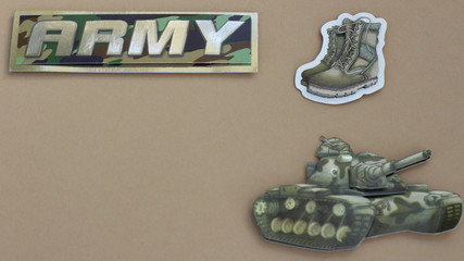 army sign next to army boots and tank laying flat on a tan background with writing space