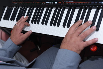 Closeup of man's hands playing piano