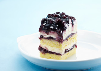 Delicate blueberry jam cake over white background