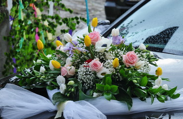  bouquet of white lilies on the hood of a wedding car