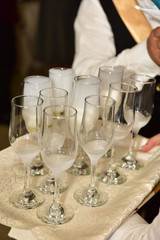 Waitress holding a dish of champagne and wine glasses at some festive event,