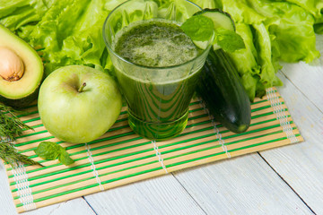 Healthy green smoothie with ingredients on wooden background