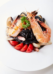 Delicious prawns with squid sauce pasta over white background