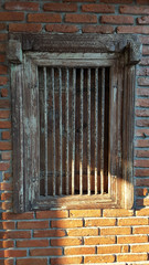 Detail shot of an old brick wall with barred windows for security