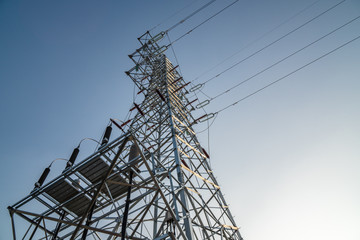 electricity pylon against blue sky