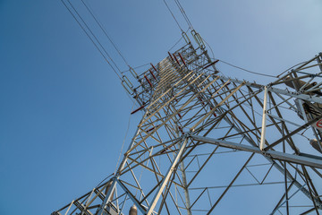 high voltage pylon against blue sky