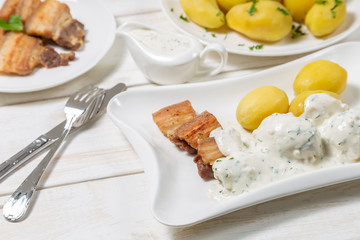 Roast pork belly with boiled potatoes and cream sauce