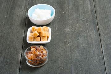 brown and white cubes and rock sugar, dark wood table
