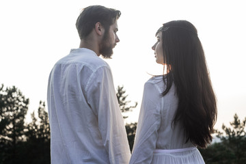Beautiful couple in love walks in the mountains, against the backdrop of rocks, in the rays of the setting sun. man and woman love each other, they are gentle and happy, a love story and a wedding day