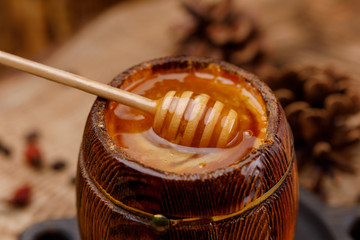 Honey spoon buried in a barrel of fragrant fresh honey.
