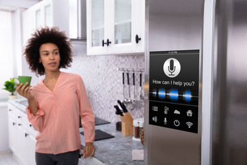 Woman Standing Near The Refrigerator With Voice Recognition
