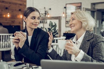 Happy mother feeling amazing sitting in cafeteria with her mother