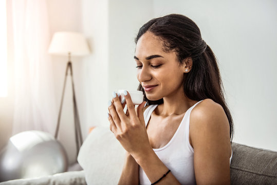 Kind international woman smelling cream for face
