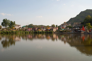 Fototapeta na wymiar Panorama of the sacred lake Revalsar on an early sunny morning. Himachal Pradesh, India