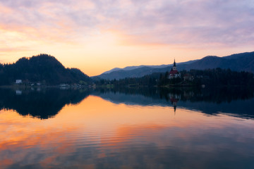 Fototapeta na wymiar Beautiful sunrise and church on Lake Bled in Slovenia at the springtime
