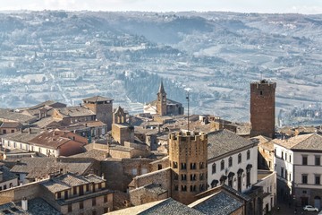Obraz premium An Italian hilltop town sits high above the countryside in the distance.