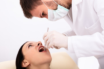 Fototapeta na wymiar Dentist Examining Woman's Teeth