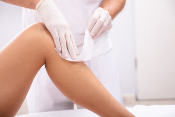 Beautician Waxing Woman's Leg